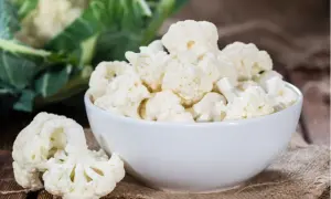 Frischer blumenkohl roh essen ist gesund und lecker. Hier sind Röschen in einer Schüssel und daneben auf einem Holzbrett.