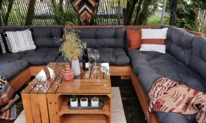 Gemütliche Lounge-Ecke mit einem selbstgebauten Palettensofa. Der Tisch ist ebenfalls aus Holzpaletten gefertigt.
