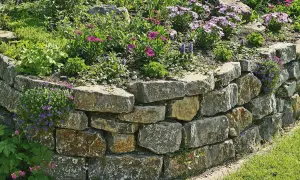 Eine rustikale Trockenmauer bauen, die mit bunten Blumen und grünem Gras verschönert wird.