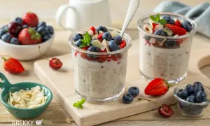 Zwei Gläser mit über Nacht eingeweichten Haferflocken, garniert mit frischen Beeren und Mandelsplittern. Ein gesunder Start in den Tag.
