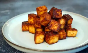 Goldbraun gebratene Tofuwürfel auf einem Teller. Perfekt zum tofu zubereiten für eine knusprige Beilage.
