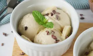 Cremiges Nice Cream Rezept in einer weißen Schale, garniert mit Minze und Kakaonibs. Ein gesunder Genuss!