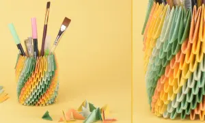 Bunter Stiftehalter aus Origami-Modulen, inspiriert von Papier Ideen. Daneben liegen bunte Papierbögen und kleine Origami-Figuren.