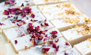 Rechteckige Seifenstücke, verziert mit Rosenblättern und Kräutern. Eine schöne Inspiration, um Seife selber herzustellen.