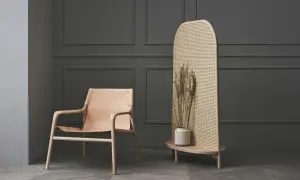Ein Ledersessel und ein Rattan-Raumteiler mit Trockenblumen – eine stilvolle alternative zu tapete für moderne Räume.