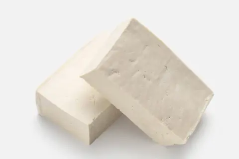 Zwei Blöcke hellbeiger Tofus liegen nebeneinander. Ist Tofu gesund? Ja, eine tolle pflanzliche Proteinquelle!