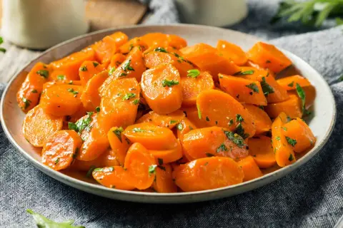Schüssel mit glasierten, bunte Karotten, garniert mit Petersilie. Ein köstliches Gericht, das Farbe auf den Tisch bringt.