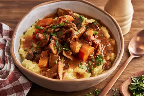 Herzhaftes pilzgulasch vegetarisch auf cremigem Kartoffelpüree, garniert mit frischer Petersilie. Ein Genuss für alle Sinne.