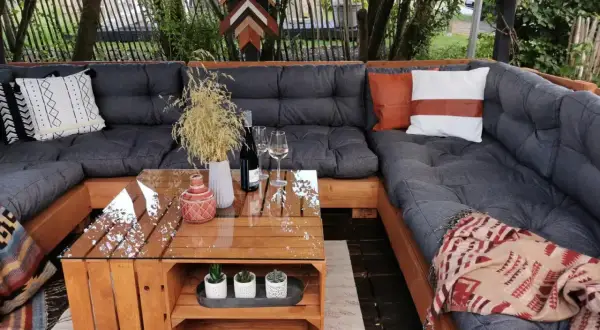 Gemütliche Lounge-Ecke mit einem selbstgebauten Palettensofa. Der Tisch ist ebenfalls aus Holzpaletten gefertigt.
