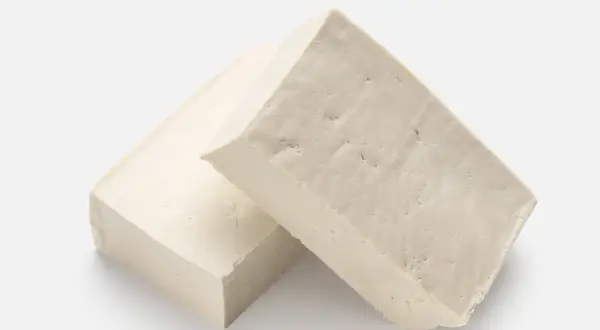 Zwei Blöcke hellbeiger Tofus liegen nebeneinander. Ist Tofu gesund? Ja, eine tolle pflanzliche Proteinquelle!