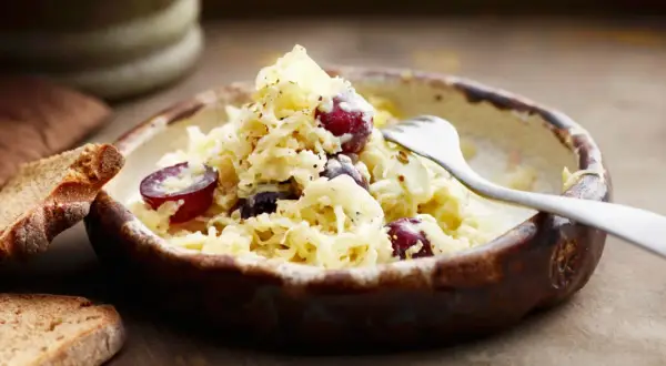 Schüssel mit Sauerkraut, Trauben und Brot. Vielleicht ist das Sauerkraut zu sauer für manche.