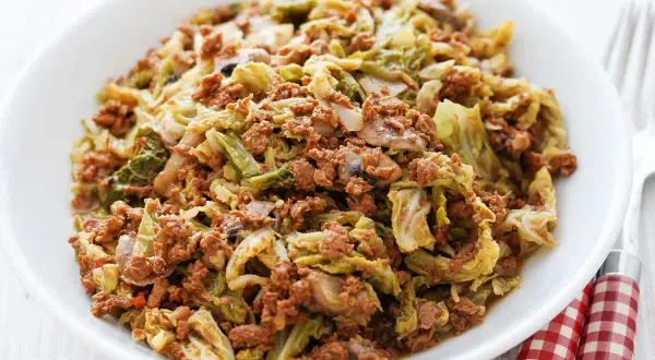 Herzhafte wirsingpfanne vegetarisch mit Pilzen und Hack-Alternative, serviert in einer weißen Schüssel.