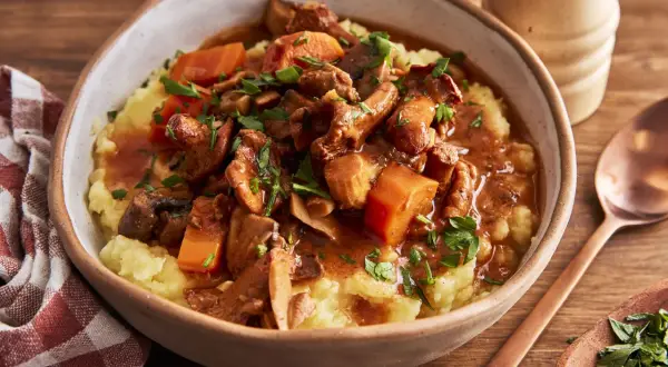 Herzhaftes pilzgulasch vegetarisch auf cremigem Kartoffelpüree, garniert mit frischer Petersilie. Ein Genuss für alle Sinne.