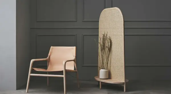 Ein Ledersessel und ein Rattan-Raumteiler mit Trockenblumen – eine stilvolle alternative zu tapete für moderne Räume.