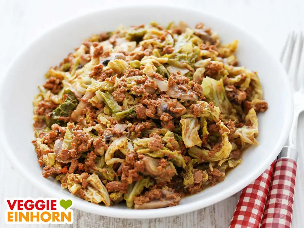 Herzhafte wirsingpfanne vegetarisch mit Pilzen und Hack-Alternative, serviert in einer weißen Schüssel.