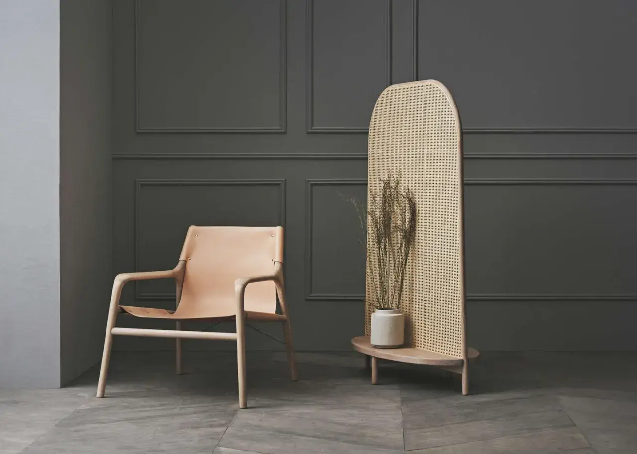 Ein Ledersessel und ein Rattan-Raumteiler mit Trockenblumen – eine stilvolle alternative zu tapete für moderne Räume.