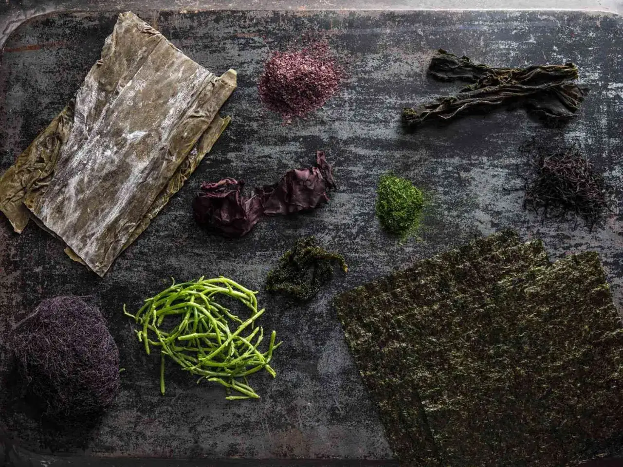 Verschiedene getrocknete Algenarten liegen bereit, um sie zuzubereiten: Kombu, Nori, Wakame und mehr.