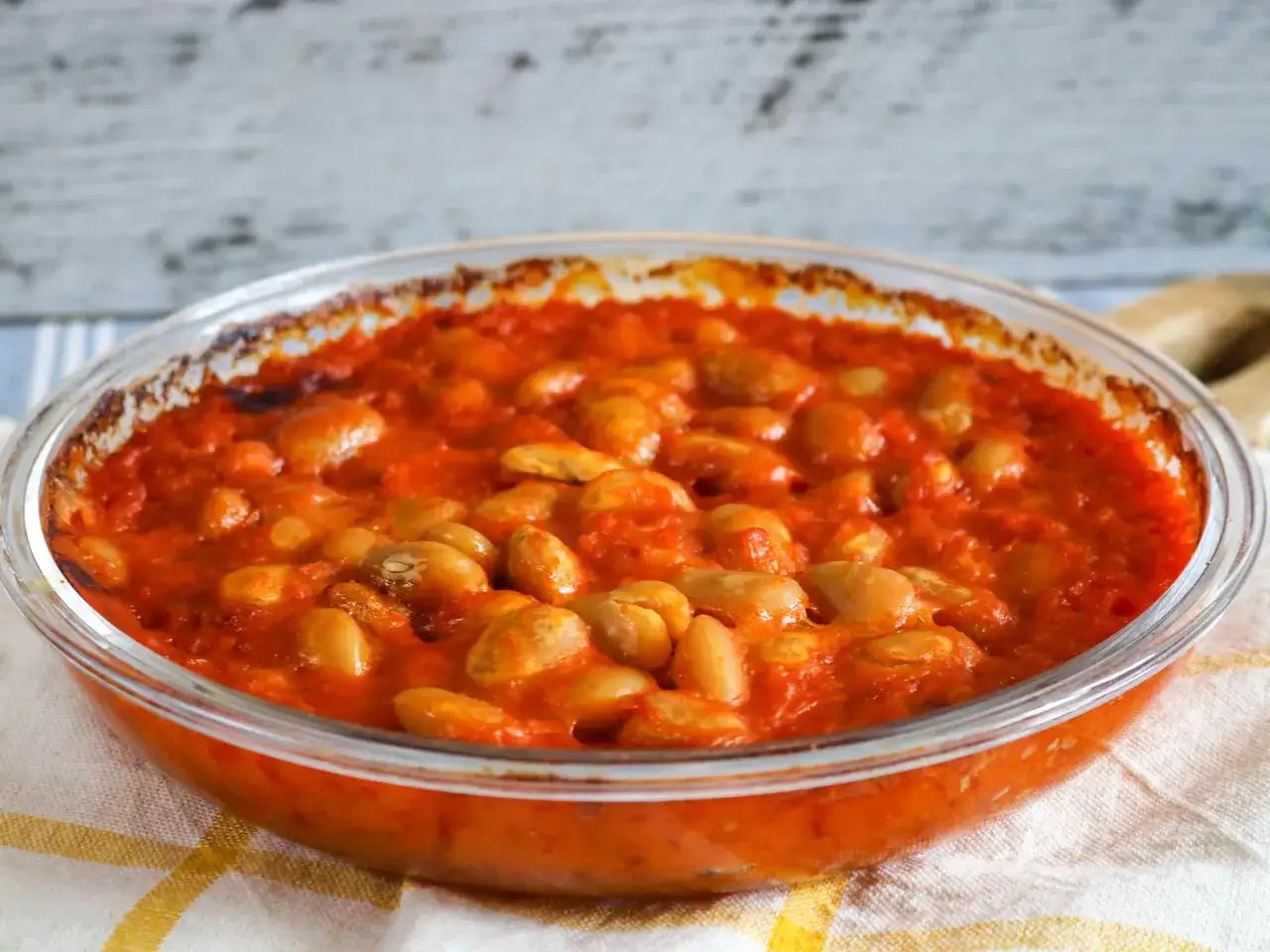 Herzhaftes Fasolakia Rezept in Tomatensauce, in einer Glassch&uuml;ssel serviert.