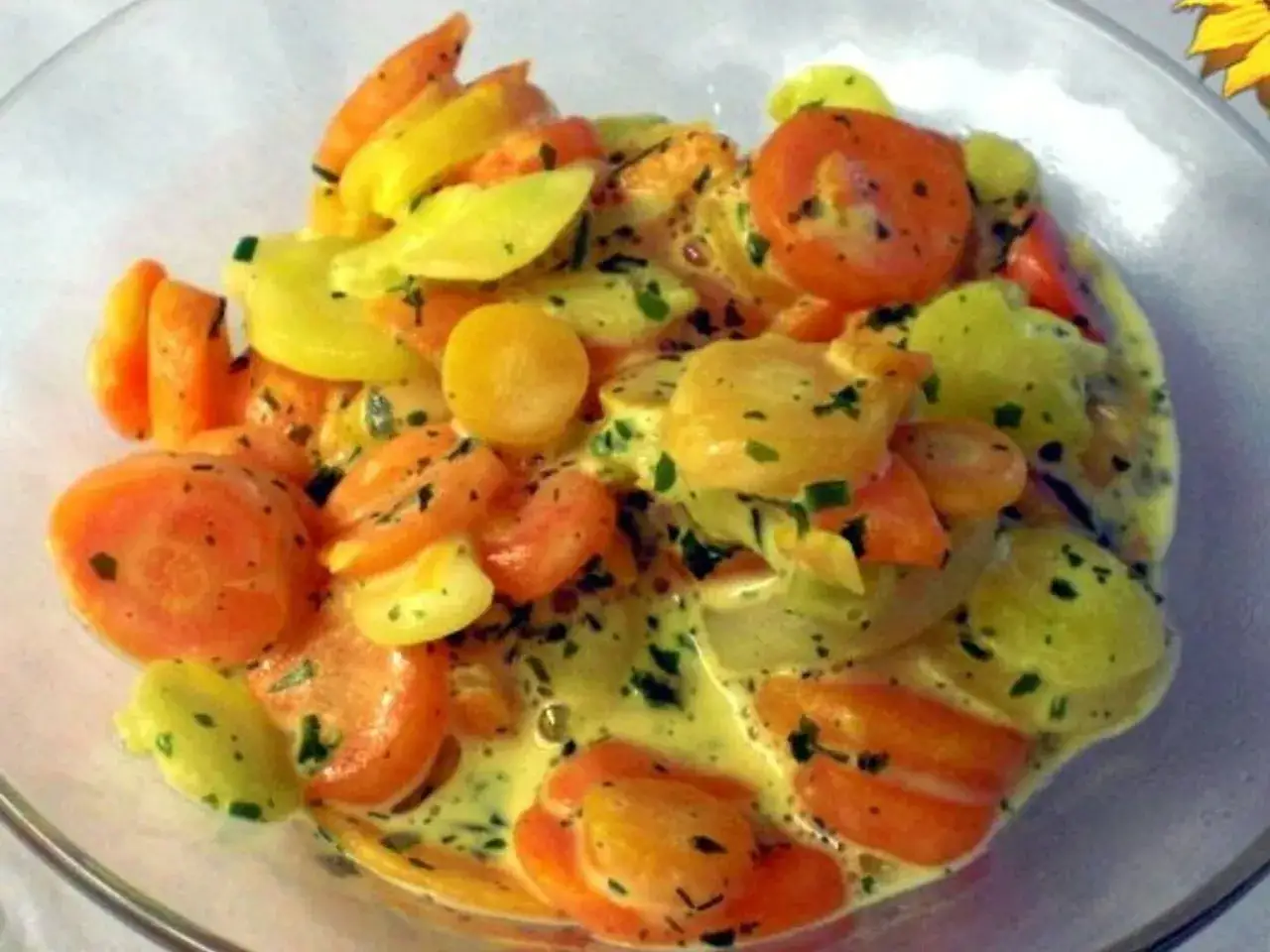 Bunte Karotten in cremiger Sauce, garniert mit Kr&auml;utern. Ein farbenfroher Genuss!