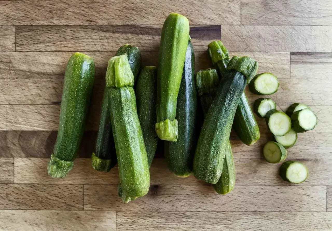 Frische Zucchini, bereit, roh gegessen zu werden. Einige sind bereits in Scheiben geschnitten, perfekt f&uuml;r einen knackigen Salat.