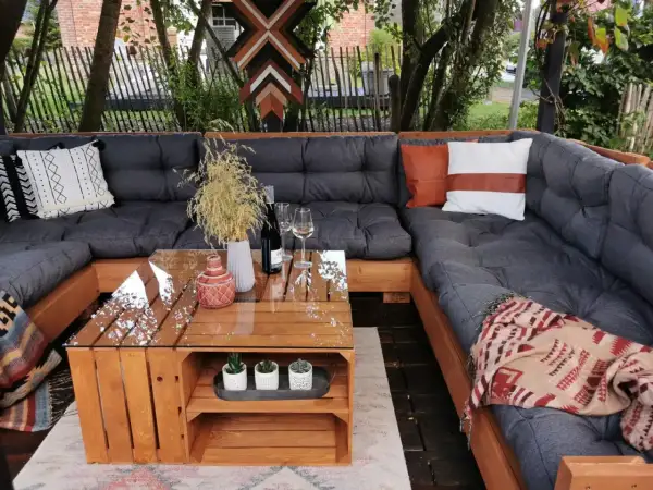 Gemütliche Lounge-Ecke mit einem selbstgebauten Palettensofa. Der Tisch ist ebenfalls aus Holzpaletten gefertigt.