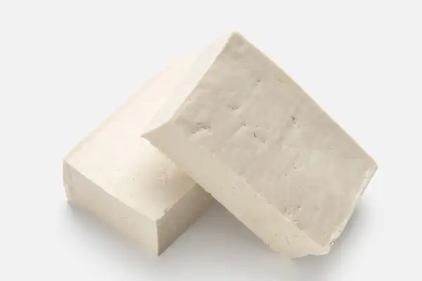 Zwei Blöcke hellbeiger Tofus liegen nebeneinander. Ist Tofu gesund? Ja, eine tolle pflanzliche Proteinquelle!