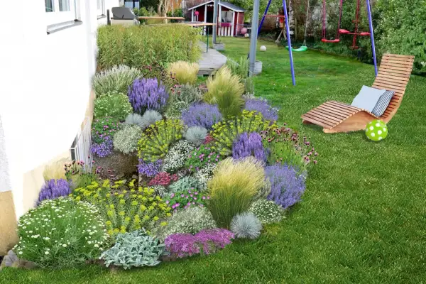Ein üppig bepflanztes Blumenbeet mit Lavendel, Gräsern und vielen kleinen Blüten neben einem Haus. Perfekt, um **Pflanzsteine bepflanzen** zu lassen und einen schönen Garten zu gestalten.