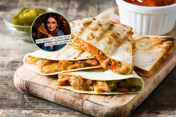 Gefüllte Quesadillas auf Holzbrett, dazu Salsa und Jalapeños. Perfekt für eine gesunde Brotzeit mit Vivi's Kochtipps.